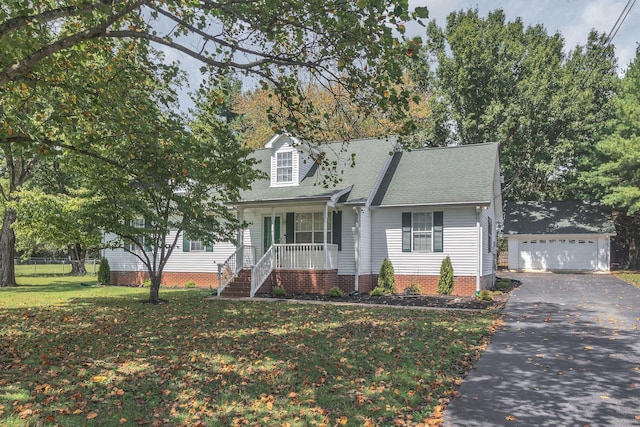 cape cod home featuring an outbuilding, covered porch, a shingled roof, a front lawn, and a detached garage