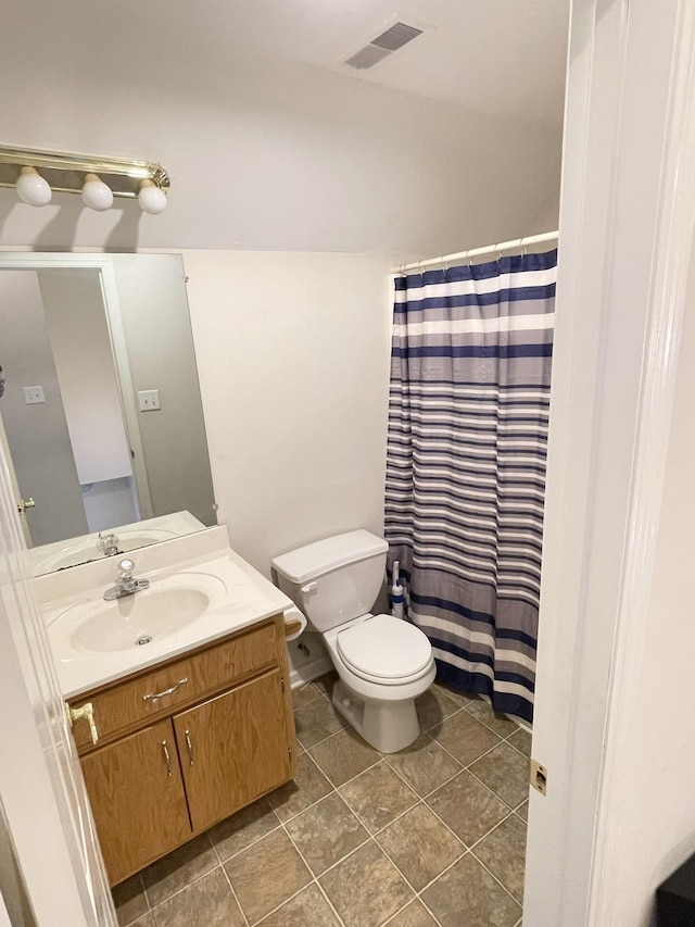 bathroom featuring vanity, a shower with curtain, visible vents, tile patterned flooring, and toilet