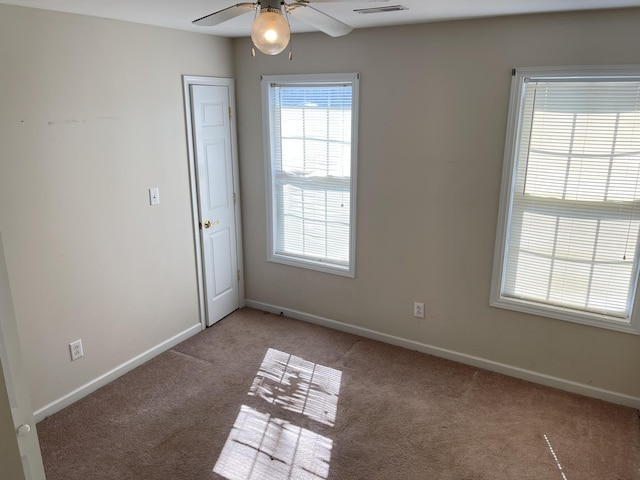 empty room featuring visible vents, ceiling fan, baseboards, and carpet floors