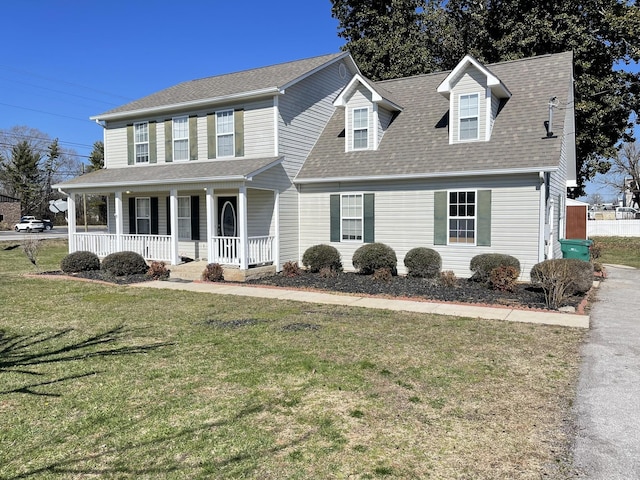 view of front of home featuring a porch, a front lawn, and a shingled roof