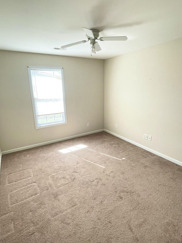 unfurnished room with a ceiling fan, carpet, and baseboards