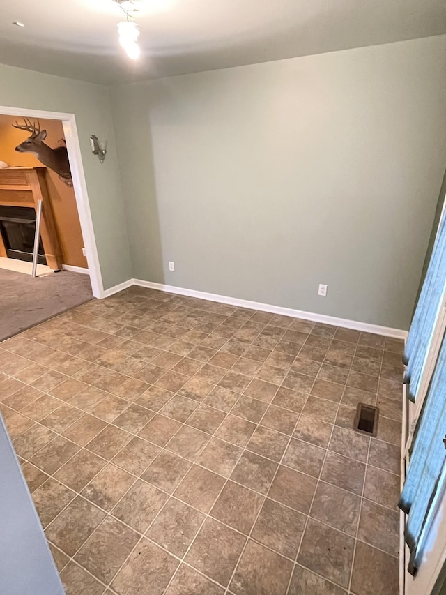 empty room with visible vents, baseboards, and a fireplace