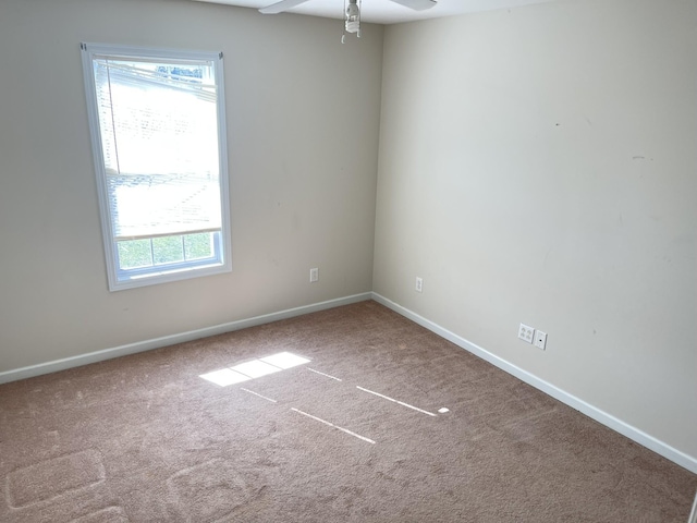 carpeted spare room with baseboards and ceiling fan