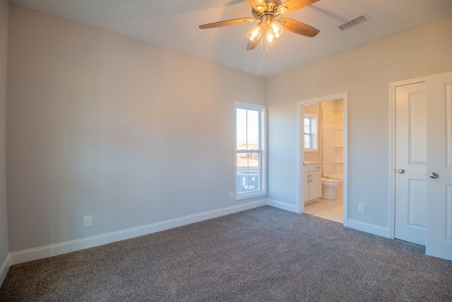 unfurnished bedroom featuring visible vents, light colored carpet, connected bathroom, and baseboards