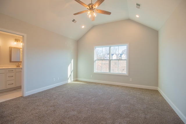 unfurnished bedroom featuring vaulted ceiling, baseboards, visible vents, and light carpet