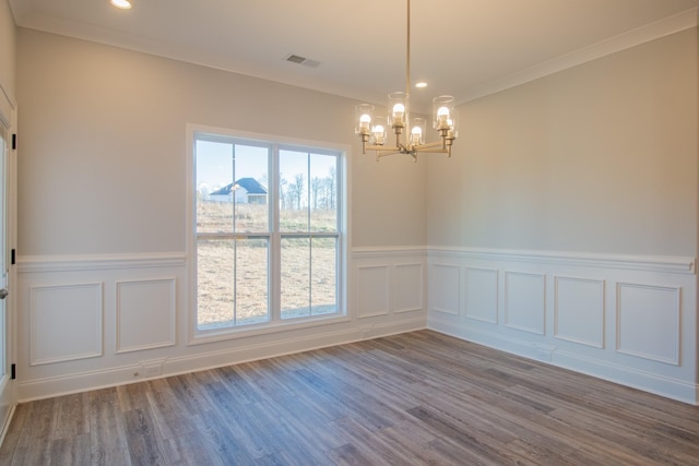 empty room with visible vents, a chandelier, ornamental molding, recessed lighting, and wood finished floors