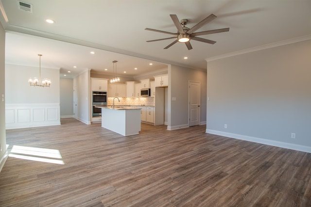 unfurnished living room with visible vents, recessed lighting, ceiling fan with notable chandelier, wood finished floors, and a sink