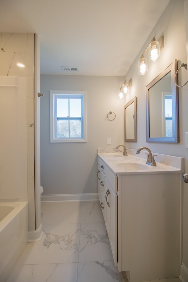 bathroom featuring visible vents, marble finish floor, baseboards, and a sink