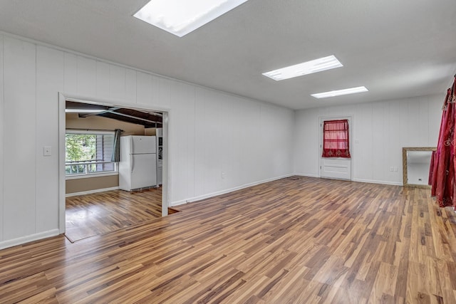 empty room with baseboards and wood finished floors