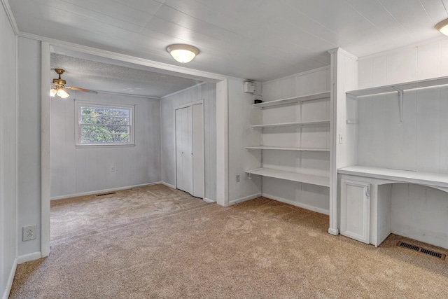 interior space featuring visible vents, baseboards, light colored carpet, and a ceiling fan