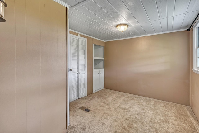 spare room with visible vents, crown molding, and carpet