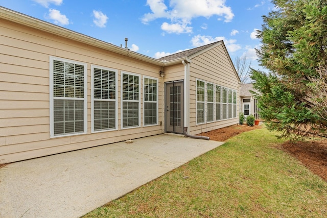 back of property featuring a lawn and a patio area