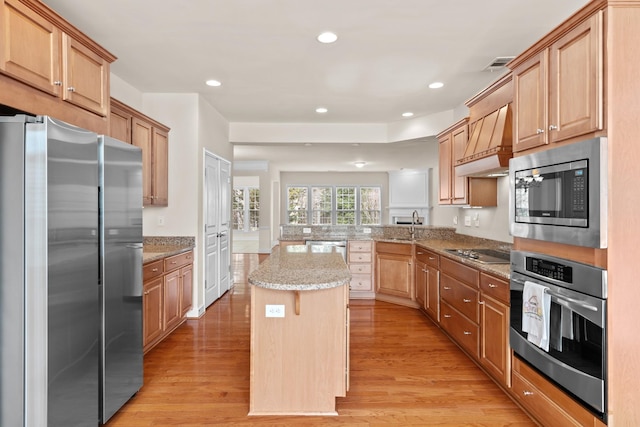 kitchen featuring light wood finished floors, visible vents, appliances with stainless steel finishes, and a center island