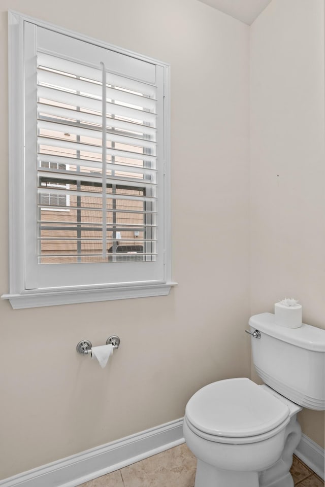 bathroom with tile patterned floors, baseboards, and toilet