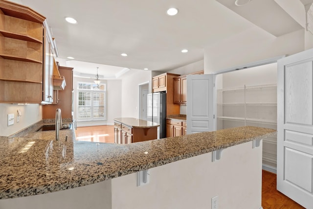 kitchen with light stone counters, wood finished floors, open shelves, recessed lighting, and freestanding refrigerator