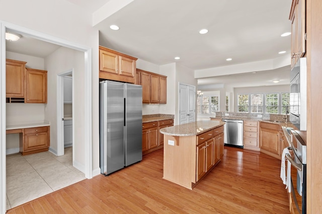 kitchen with light wood-style flooring, recessed lighting, a kitchen island, and stainless steel appliances