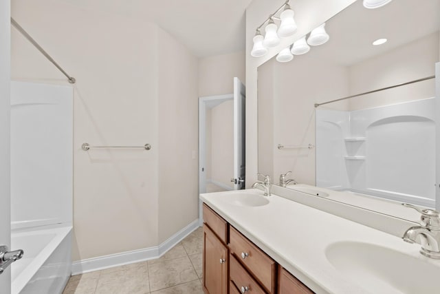 full bath featuring tile patterned floors, double vanity, baseboards, and a sink