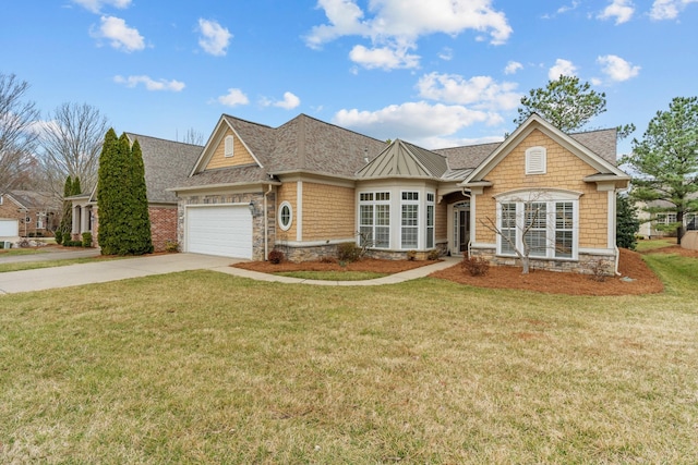 shingle-style home with concrete driveway, an attached garage, a front lawn, and stone siding