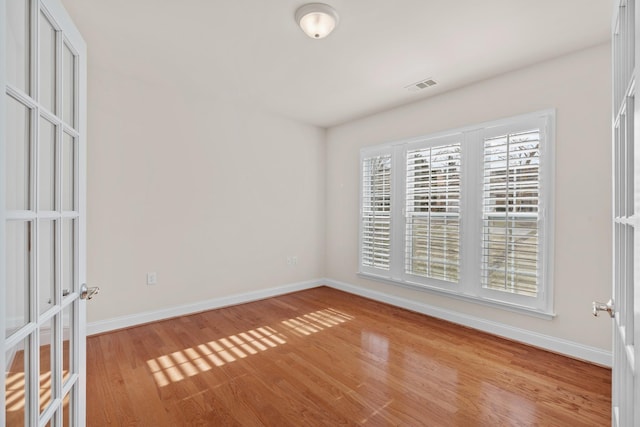 spare room featuring visible vents, baseboards, and light wood-style floors