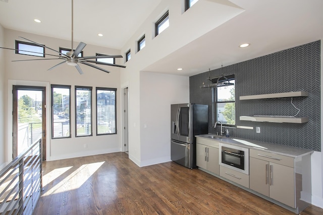 kitchen featuring a sink, stainless steel fridge, dark wood-type flooring, and a healthy amount of sunlight