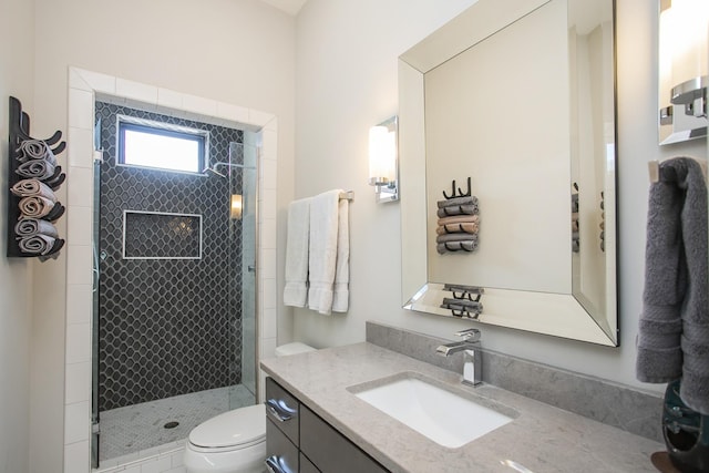 full bathroom featuring a stall shower, toilet, and vanity