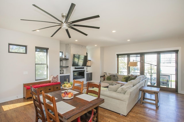 living room with recessed lighting, a fireplace, a ceiling fan, and wood finished floors