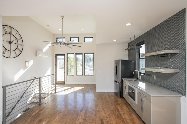 kitchen with open shelves, oven, an AC wall unit, wood finished floors, and a sink