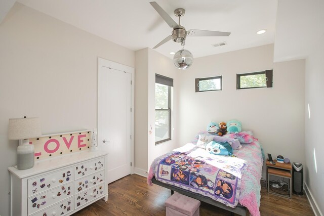 bedroom featuring visible vents, a ceiling fan, baseboards, and wood finished floors