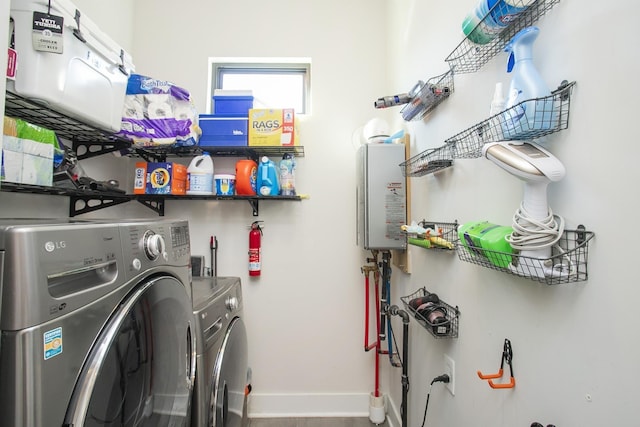 washroom with baseboards, washing machine and dryer, laundry area, and water heater