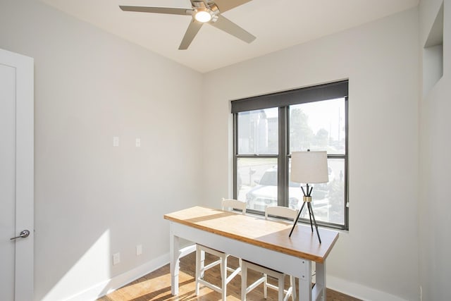 home office featuring baseboards, ceiling fan, and light wood finished floors