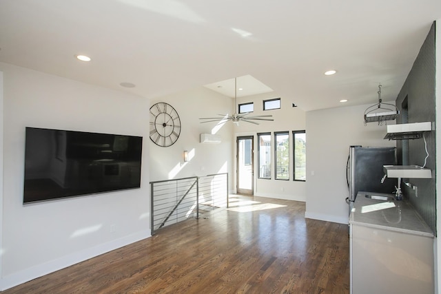 unfurnished living room featuring recessed lighting, wood finished floors, baseboards, and a wall mounted air conditioner