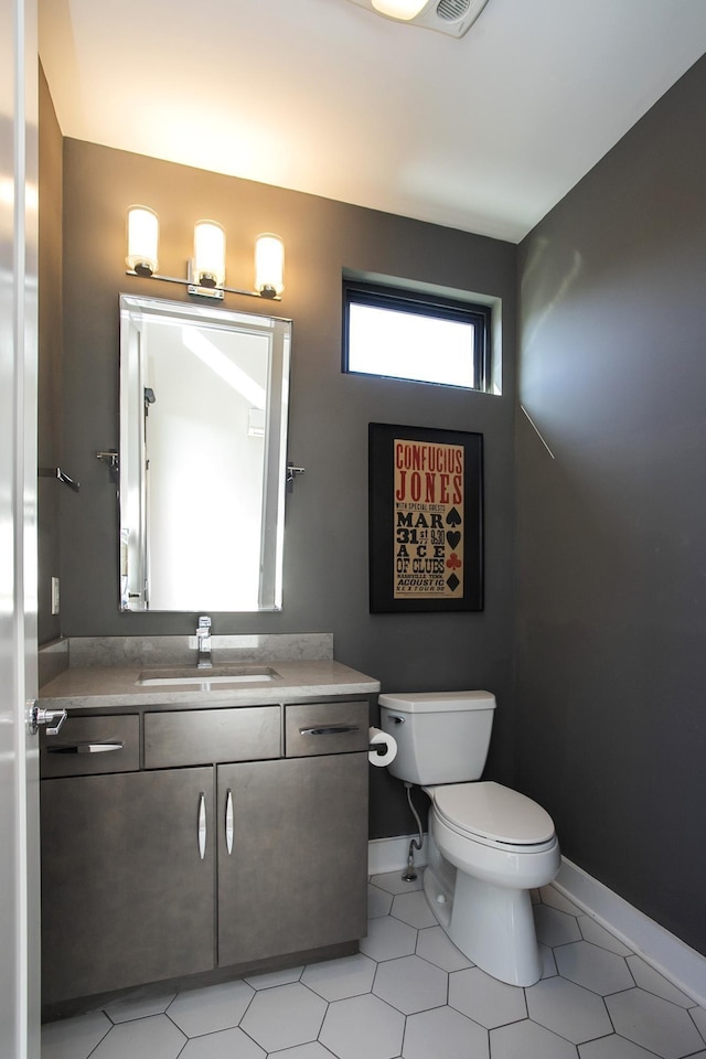 bathroom with baseboards, toilet, and vanity