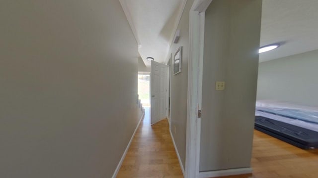 hallway featuring baseboards and light wood finished floors