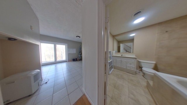 bathroom featuring visible vents, toilet, a bath, tile patterned floors, and vanity