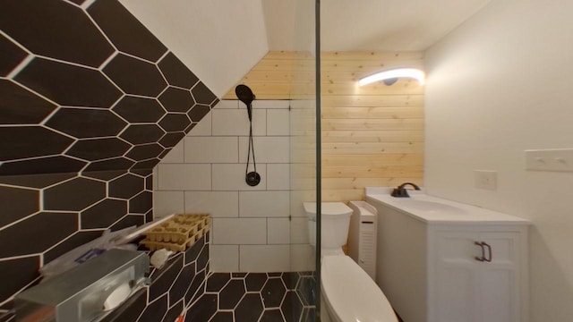 full bathroom with toilet, tiled shower, wood walls, and a sink