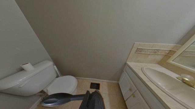 half bathroom featuring tile patterned flooring, toilet, vanity, and baseboards