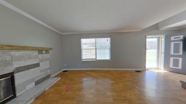 unfurnished living room featuring a stone fireplace, crown molding, baseboards, and lofted ceiling