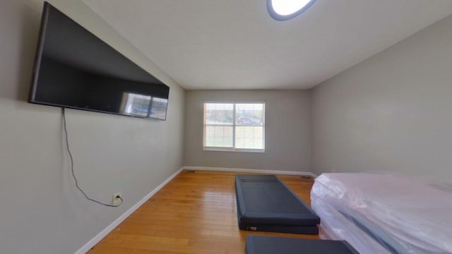 bedroom with light wood-style floors and baseboards