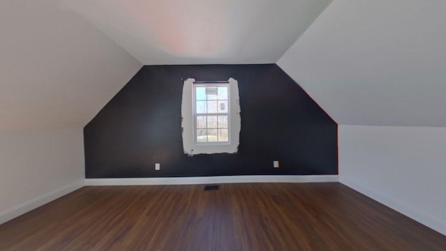 additional living space featuring lofted ceiling, baseboards, and wood finished floors