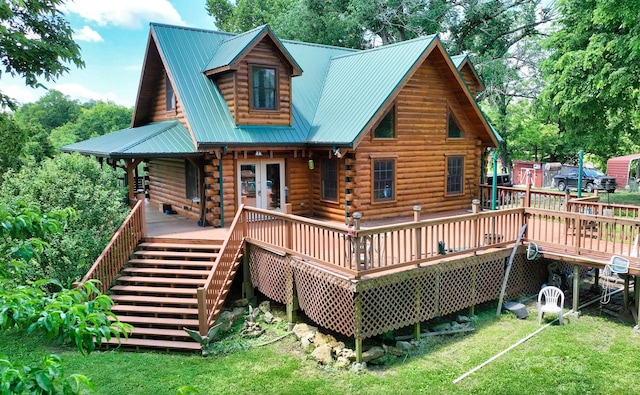 back of property with a lawn, french doors, metal roof, log siding, and stairs