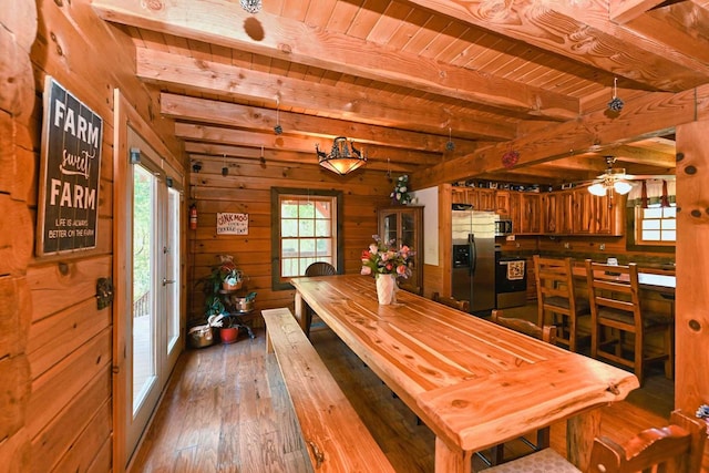 dining area with plenty of natural light, beam ceiling, and hardwood / wood-style floors