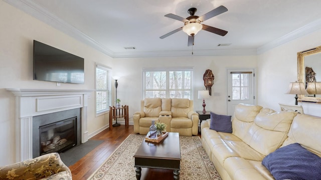 living room with visible vents, wood-type flooring, a fireplace with flush hearth, and ornamental molding