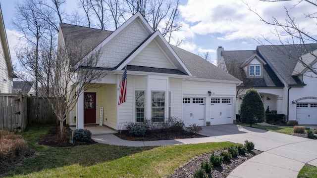 view of front of property with fence, a chimney, a shingled roof, concrete driveway, and a garage