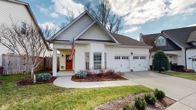 view of front of house featuring driveway, a front lawn, a garage, and fence