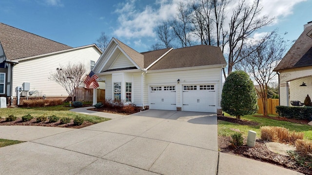 view of front of home featuring concrete driveway, an attached garage, fence, and roof with shingles