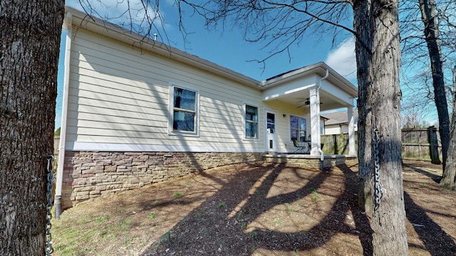 exterior space featuring ceiling fan and fence