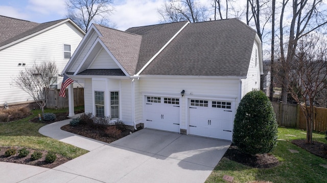 view of front of property with a garage, roof with shingles, driveway, and fence