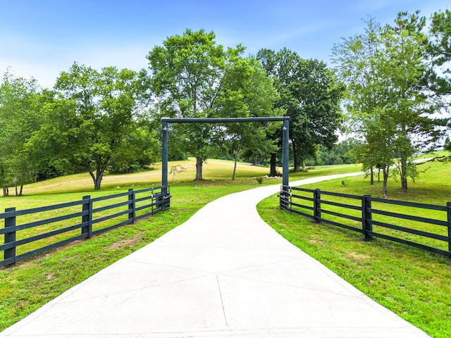 view of property's community with a lawn and fence