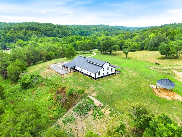 drone / aerial view featuring a rural view and a wooded view