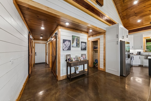 corridor with recessed lighting, wooden ceiling, concrete flooring, and a barn door